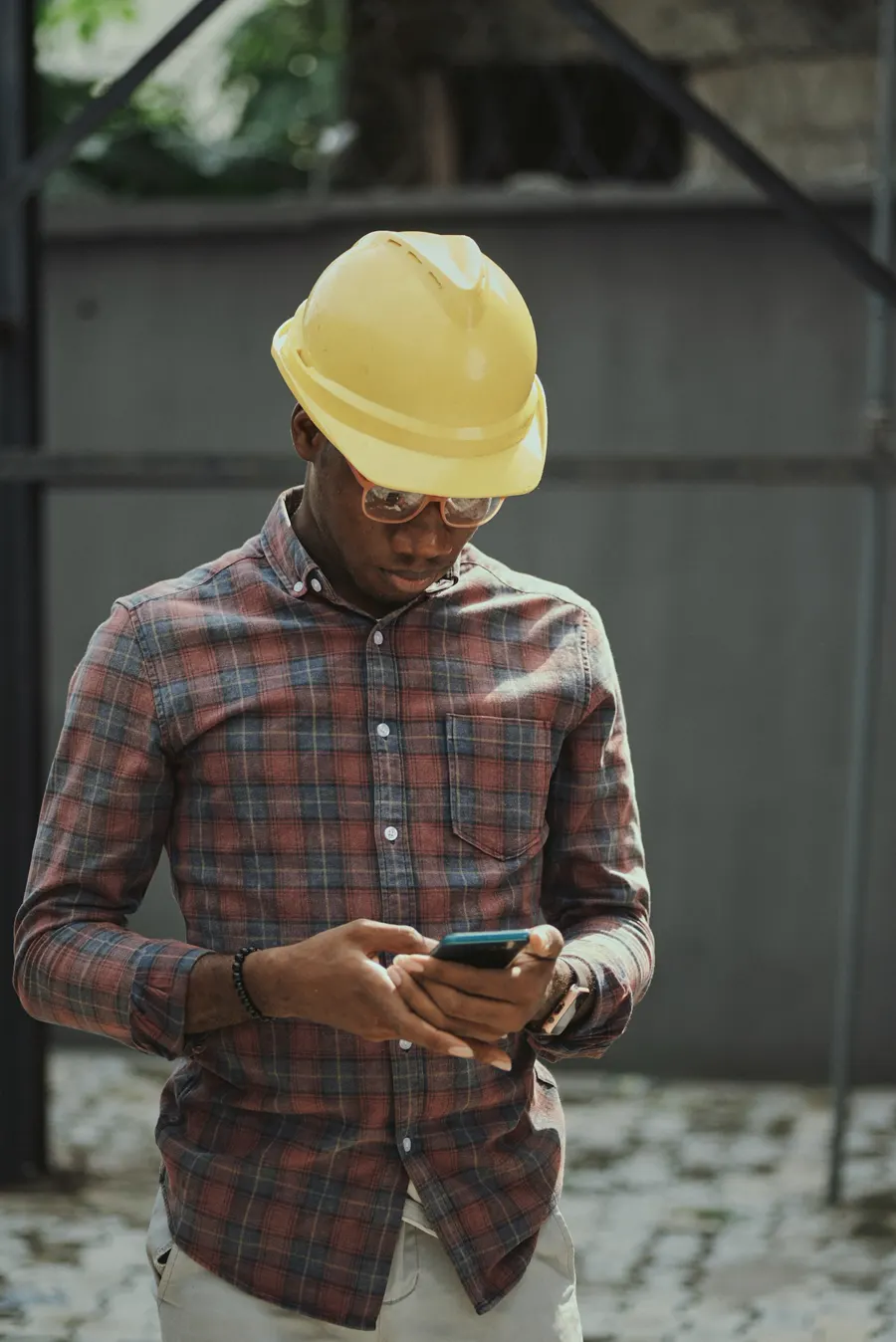 A contractor in a hard hat checks a new booking on his phone